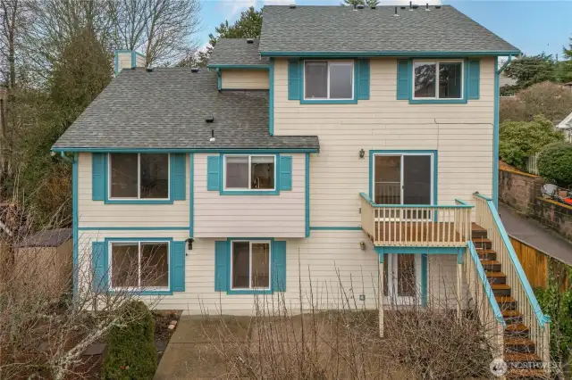 Back view of the house - showing all three levels, good-sized deck, and large patio.