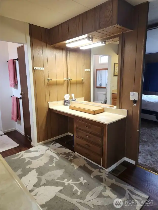 Opposite the double sinks is a built-in make-up vanity space. You can see the entry into the main 3/4 bathroom and the door to the linen closet.