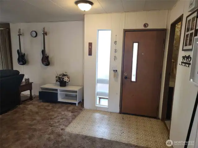 Front door and entry way with great/living room on one side and 3/4 bathroom on the other.