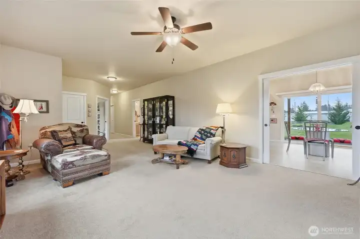 Ceiling fan, neutral peaceful color, white trim. Pocket doors separate the kitchen.