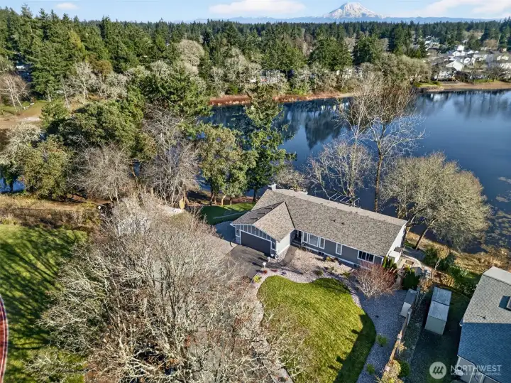 Private 1.1-acre, no-bank lakefront retreat with dock, spacious driveway parking, and serene evergreen views.