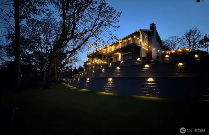 115’ no-bank lakefront with private dock, terraced lawn, and custom retaining wall with integrated lighting.