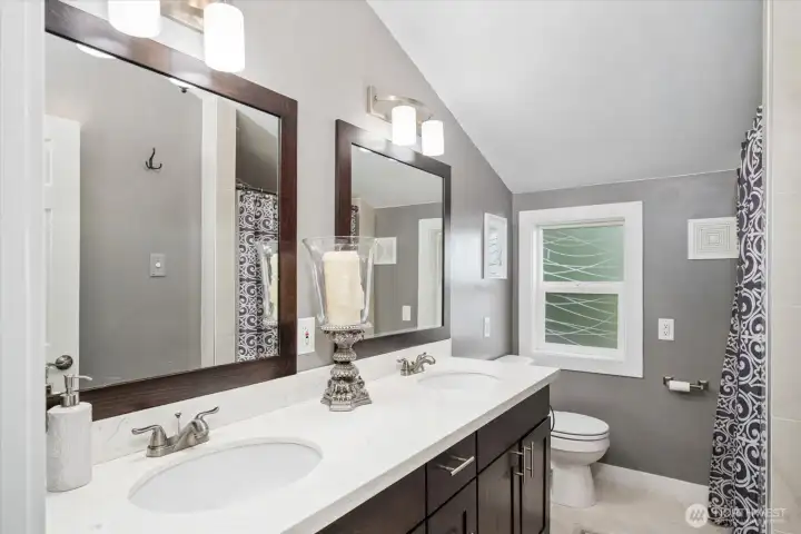 Spacious upper level bathroom with beautiful double vanity and a large walk in shower.