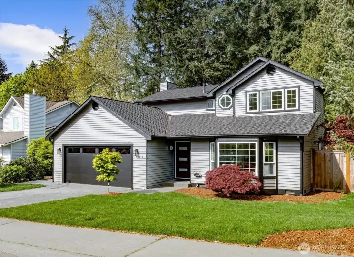 Well-maintained curb appeal with a manicured lawn, ornamental plantings, and a welcoming covered entry — nestled in a quiet, established neighborhood.