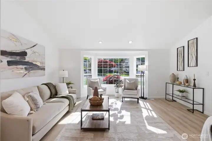 Generous living space bathed in natural light from a picturesque bay window, with warm flooring and a clean, neutral palette that complements any design style.