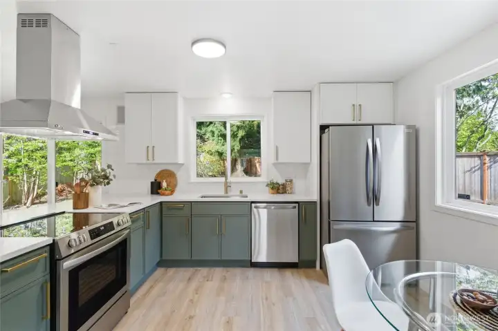 Thoughtfully designed with a stainless range, wall-mount hood, subway tile backsplash, and ample counter space — a functional and stylish space that opens to the backyard.