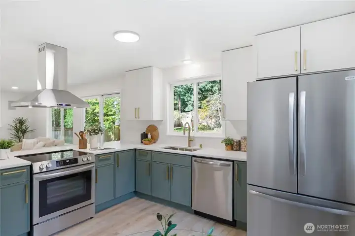 Another angle highlights the full kitchen footprint, stainless appliance suite, wall-mount range hood, and seamless connection to both the dining area and backyard access.