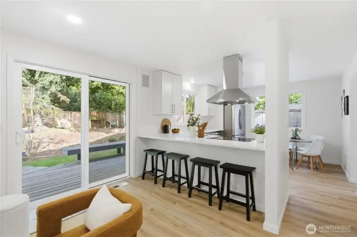 The peninsula kitchen flows directly into the family room with a slider to the back deck — a layout built for easy indoor-outdoor living.