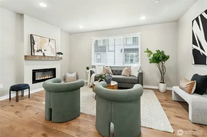 Inviting living area anchored by an electric fireplace and abundant natural light.
