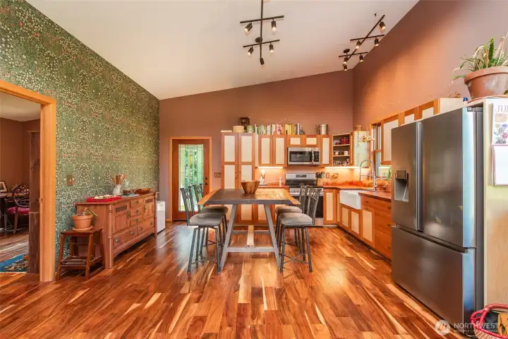 The kitchen showcases custom cabinetry and a single-slab sapele countertop and backsplash. Stunning Acacia flooring throughout. The kitchen showcases custom cabinetry and a single-slab sapele countertop and backsplash. Stunning Acacia flooring throughout.