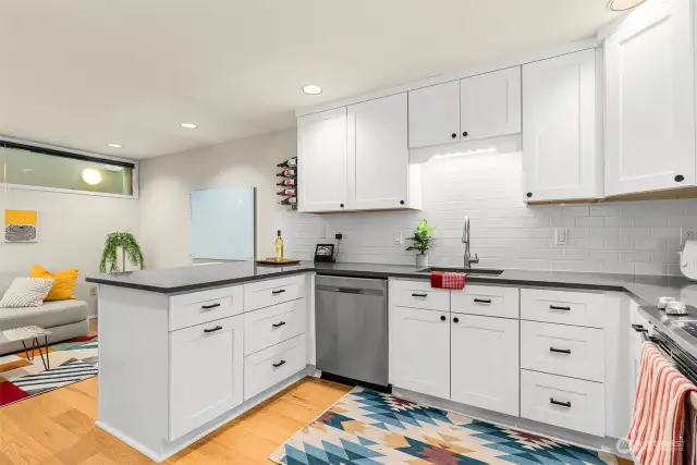 The bright updated kitchen has quart countertops, soft close drawers and hidden garbage and recycling receptacles.