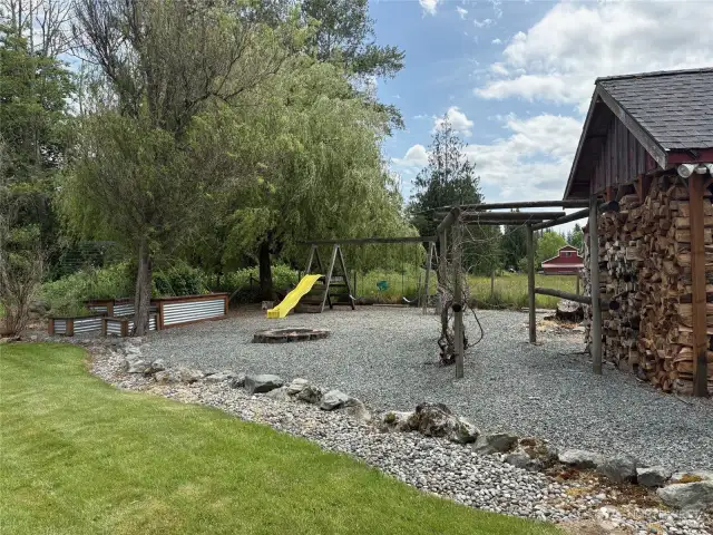 Swing set, fire pit and wood shed.