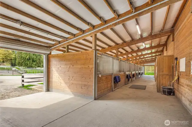 Arena barn offers 12 stalls, paddocks off each with matted floors, Centaur fencing, and Client tack lockers