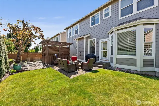 Landscaped back yard with brick and rock patio