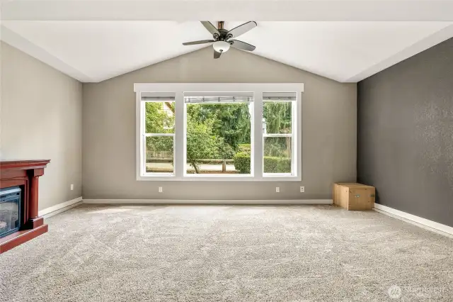 Living room features fan & vaulted ceiling
