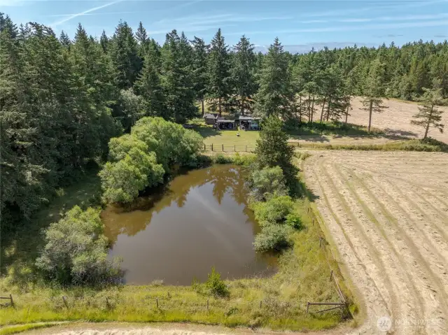 The fully fenced pond is near the rustic camp area.