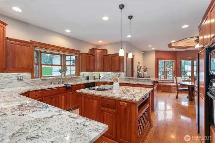 The kitchen is a true showpiece, featuring rich wood cabinetry, granite countertops, a built-in wine rack, and under-cabinet lighting that highlights every detail.