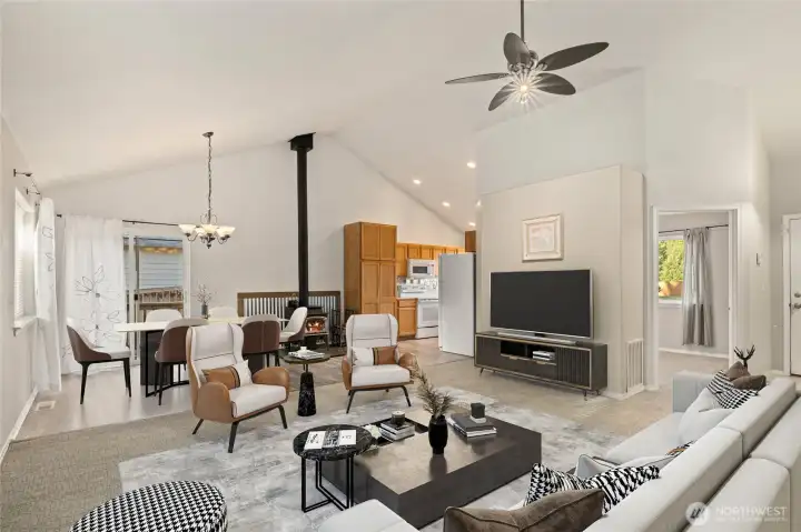Virtually staged front room and dining area. Vaulted ceilings throughout main living area. Living room and slider curtains do not stay with the home. The open door on the right is a bedroom.