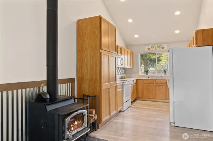 White appliances and light cabinets for the bright feel. Large window that overlooks the front yard.