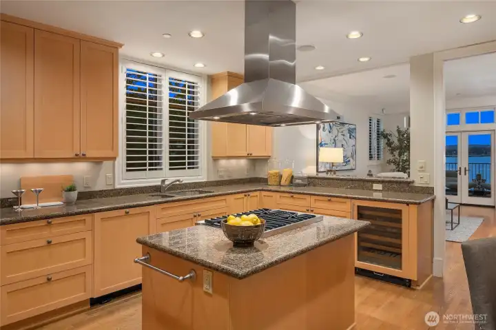 The kitchen offers a spacious island, ample storage, and a wine fridge.