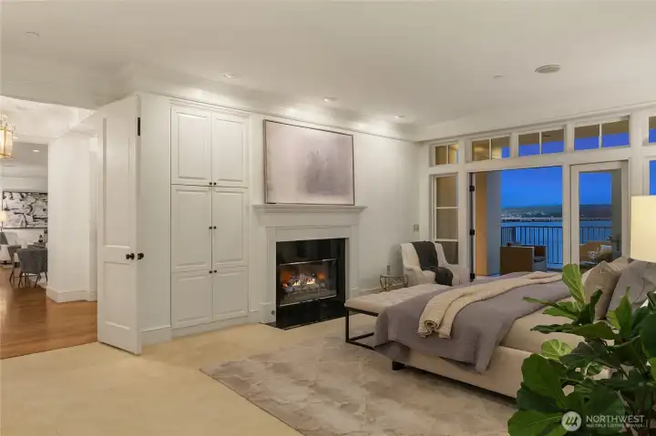 The spacious primary suite offers a peaceful retreat with soft natural light, a cozy fireplace, and direct access to a private deck.