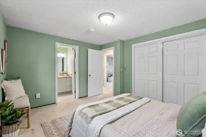 Another view of the primary suite looking towards the hall and private 3/4 bathroom