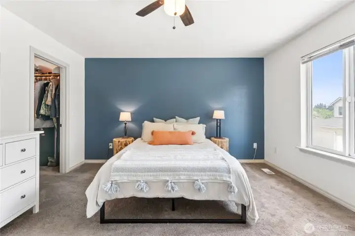 Large primary bedroom with a ceiling fan, generous floor space, and walk-in closet. Large primary bedroom with a ceiling fan, generous floor space, and walk-in closet.