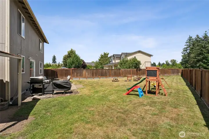 spacious fully fenced backyard featuring mature trees, raised garden beds, a storage shed, and playset that will remain with the home. spacious fully fenced backyard featuring mature trees, raised garden beds, a storage shed, and playset that will remain with the home.