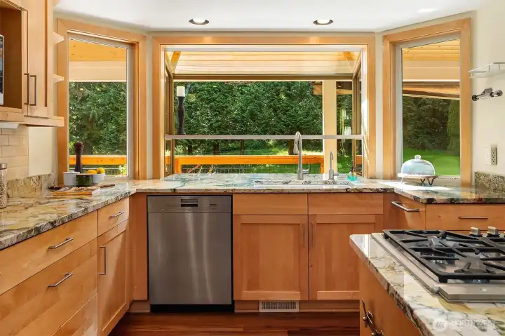Kitchen window overlooks the peaceful backyard while natural light fills the workspace Kitchen window overlooks the peaceful backyard while natural light fills the workspace