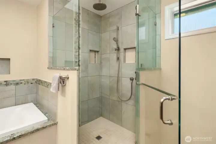Walk-in shower features tile surround and frameless glass enclosure Walk-in shower features tile surround and frameless glass enclosure
