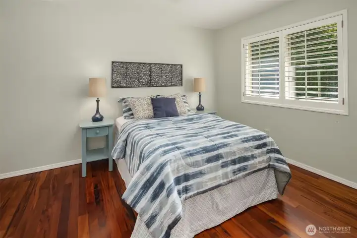 Bedroom with hardwood floors, large window, and comfortable layout Bedroom with hardwood floors, large window, and comfortable layout