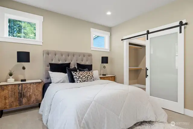 Primary suite easily accommodates these 2 large nightstands. The barn door provides access to the bath & 2 closets.