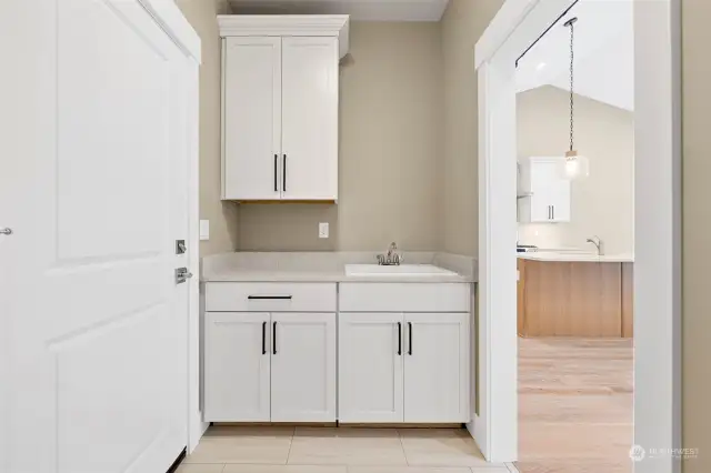 The utility room does not lack. A wall of cabinets with laundry sink across from the washer/dryer wall.