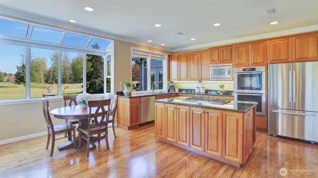 Sparkling kitchen and casual eating space highlighted by sky wall and gorgeous golf course views.