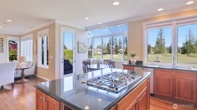 The large island features a granite top with Miele gas cooktop and tons of storage.
