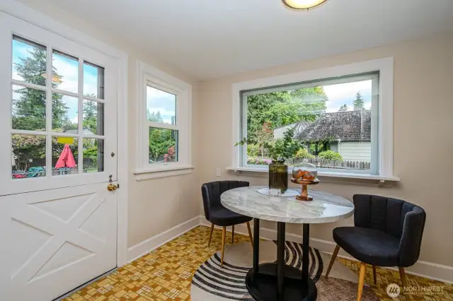 The Kitchen Nook is bright and airy with windows on three sides and a Dutch door that opens to the Trex deck and backyard beyond.