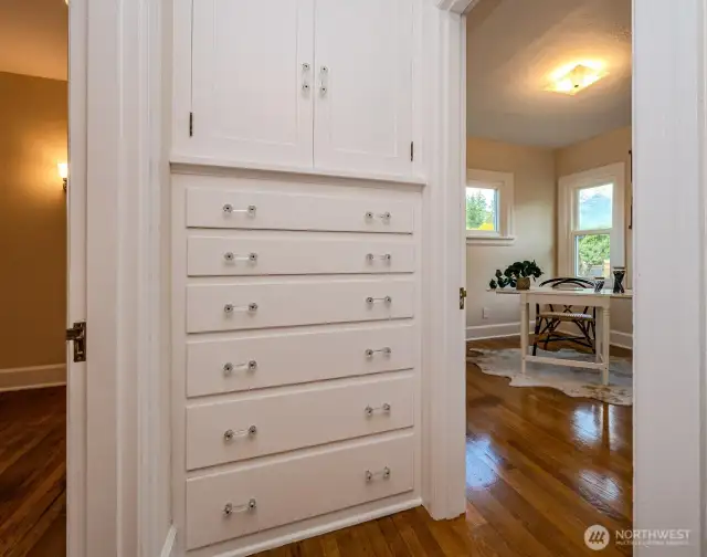 At the end of the hallway you'll find more stunning built-ins! Store your linens and other household essentials in this beautiful linen cabinet located between Bedrooms #1 and #2. Love the charming original hardware and trim!