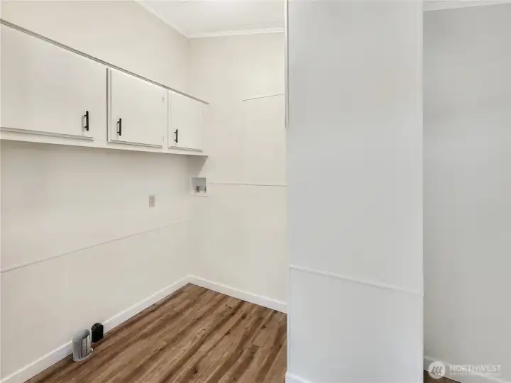 Functional laundry room with exterior access and space for added storage or shelving.