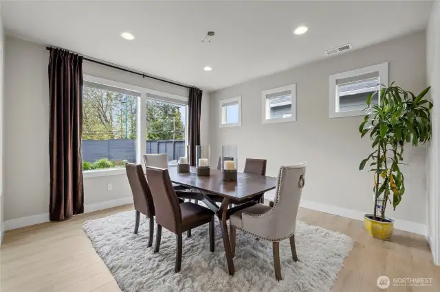 Dining area filled with natural light – drapery included.