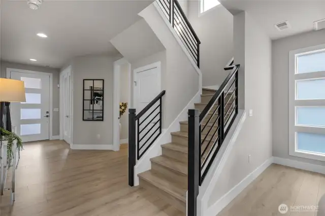 Stylish metal rail staircase leads to the upper level.