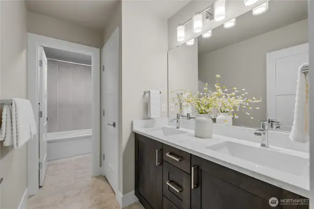 Full bath with double vanity and separate shower/toilet area.