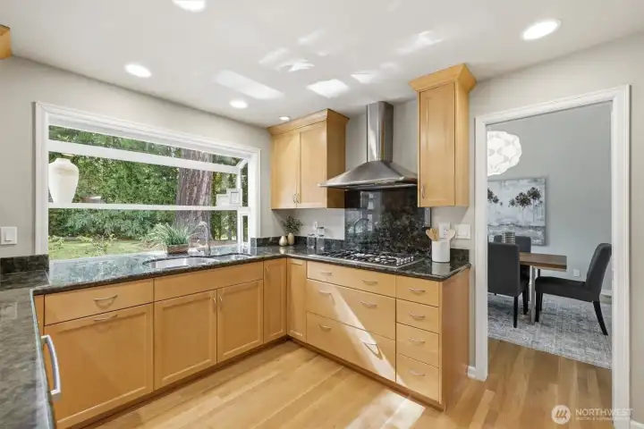 Gourmet kitchen featuring slab granite countertops, custom cabinetry, and stainless appliances