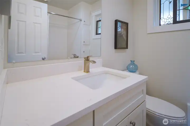 Remodeled bath with quartz counters, undermount sink, updated fixtures and lighting