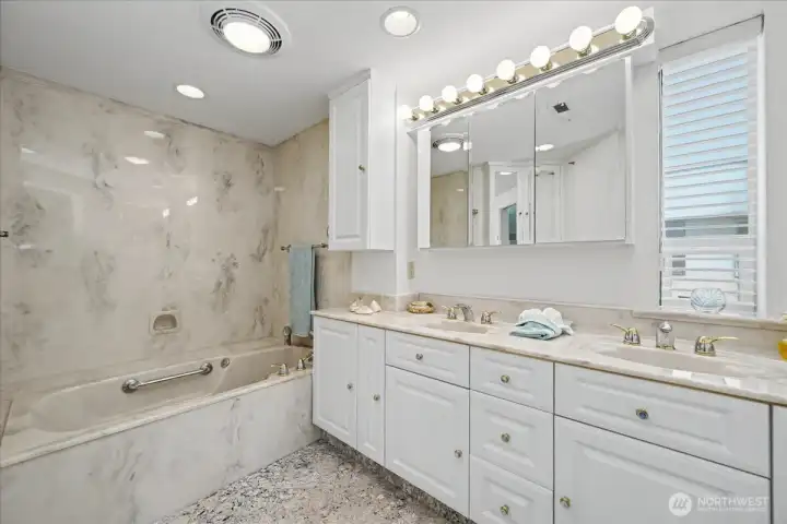A bright and inviting  en-suite bath with jetted tub, handheld shower & double vanity.