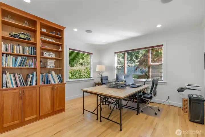 Large main level office space perfect for working from home! This room is large enough for two oversized desks, and features built in cabinets and shelving.