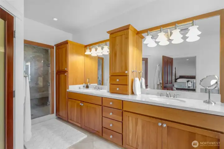 Spacious primary bathroom designed for comfort and relaxation with plenty of space for two people to have their own areas. Lots of storage here, private water closet to the left.