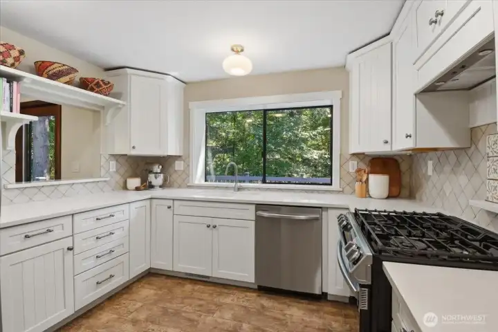 Bright and efficient kitchen with oven and gas cooktop. Stainless Steel Appliances, tile flooring, tile backsplash, and solid surface countertops. Bright and efficient kitchen with oven and gas cooktop. Stainless Steel Appliances, tile flooring, tile backsplash, and solid surface countertops.