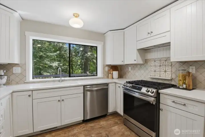 Kitchen window overlooking deck and wooded backyard. Kitchen window overlooking deck and wooded backyard.
