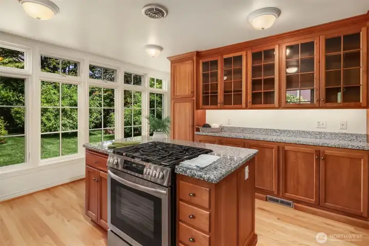 Gorgeously updated chef's kitchen framed by tall windows that keep the beauty of the backyard in view year-round