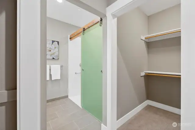 Unique glass barn door takes up no space but provides privacy for the shower & toilet compartments